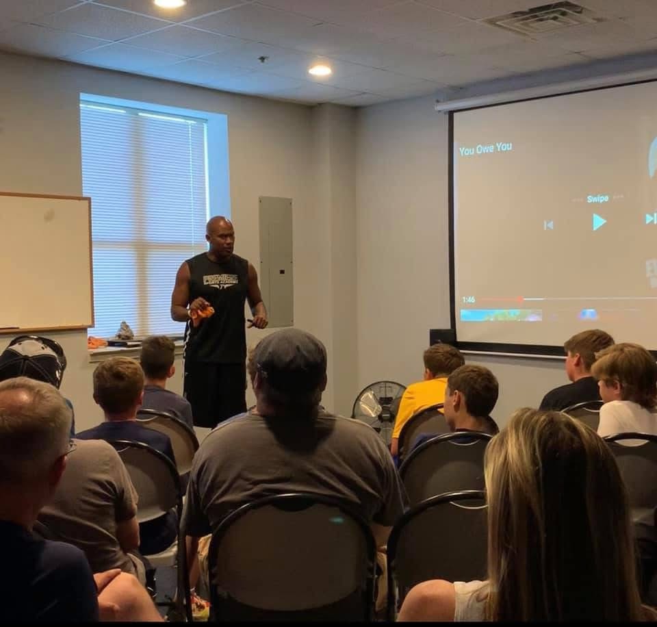 Antonio Davis presenting to a group of athletes and parents in a classroom setting